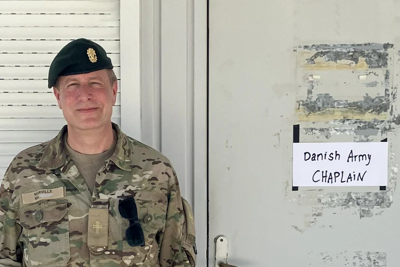 Kasper Morville Feltpræsten Kasper Morville i militæruniform foran skilt med teksten "Danish Army Chaplain".
