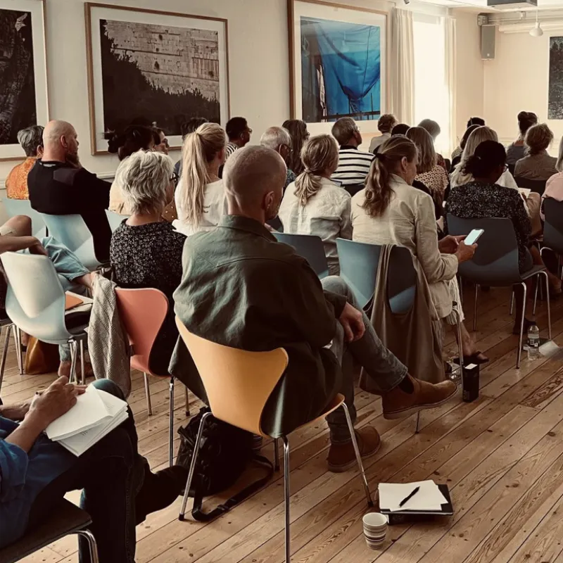 Deltagere sidder samlet i et lyst lokale under et oplæg eller seminar om moralsk skade.
